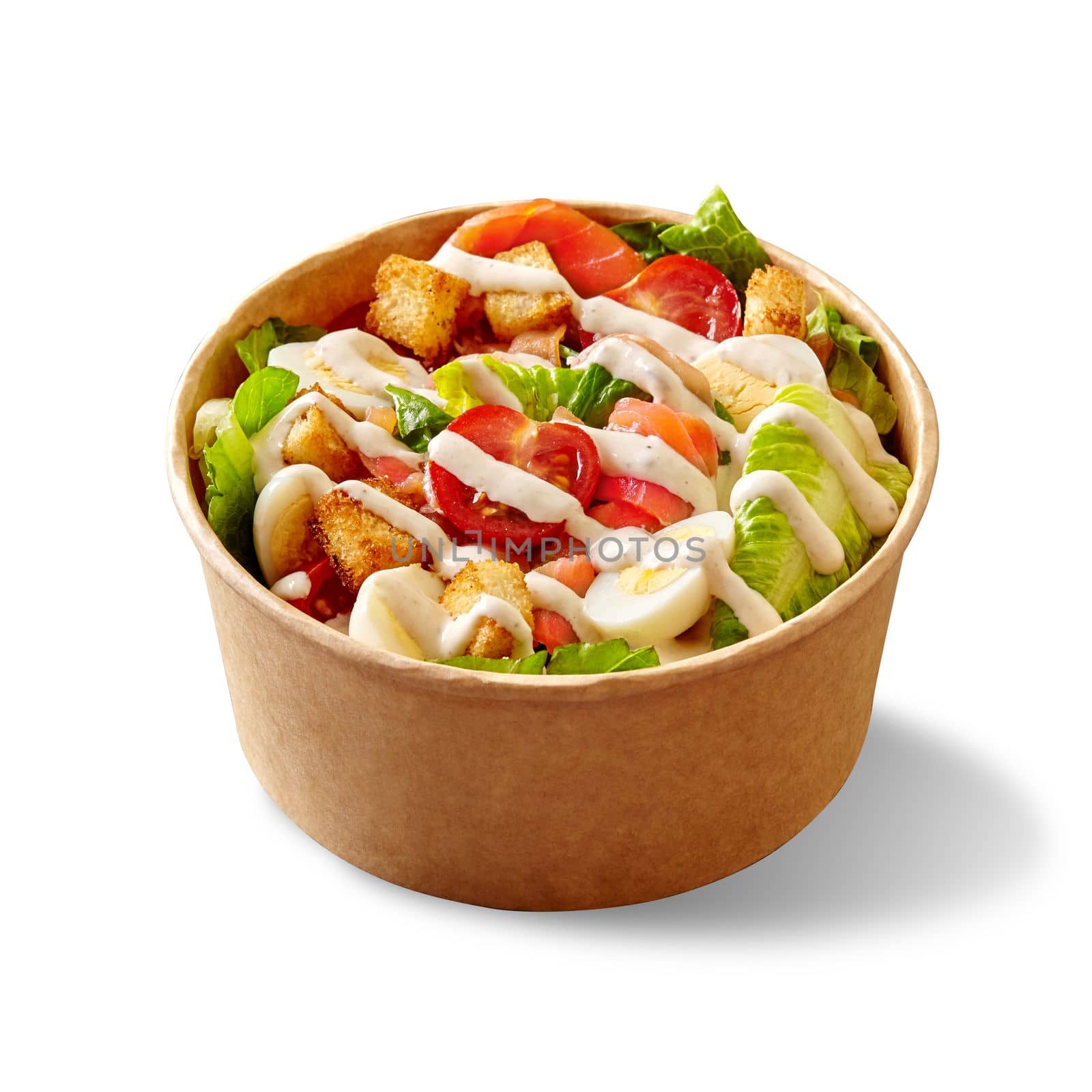 Tasty Caesar salad with green lettuce, cherry tomatoes, quail eggs, crispy croutons, parmesan and smoked salmon dressed with delicate sauce served in cardboard bowl on white. Healthy takeaway snack