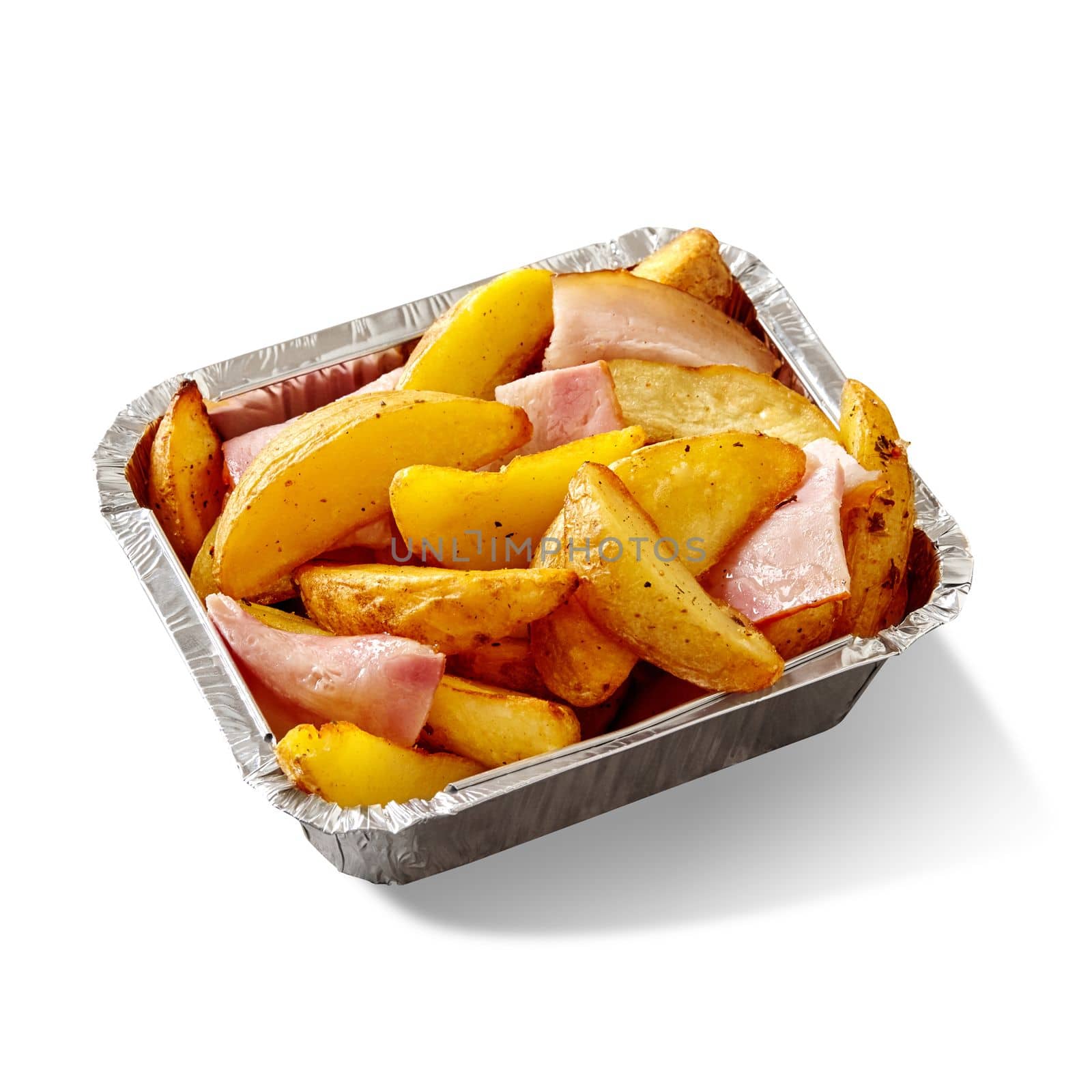 Appetizing browned crispy baked potato wedges with bacon slices served in aluminium foil container isolated on white background. Popular side dish and fast food snack. Takeaway food concept