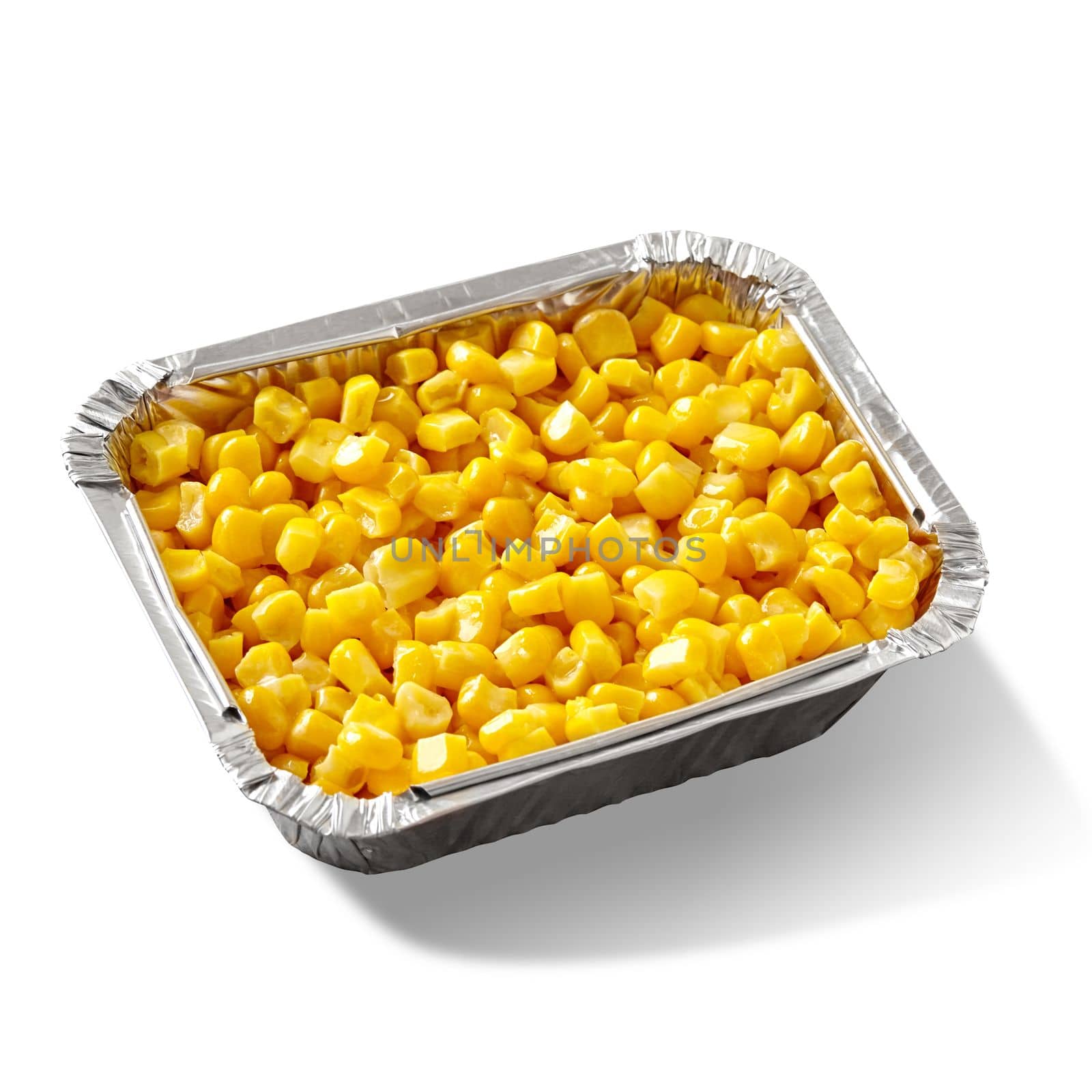 Closeup of appetizing sweet yellow boiled corn kernels in aluminium foil container isolated on white background. Delicious organic snack. Healthy takeaway food concept