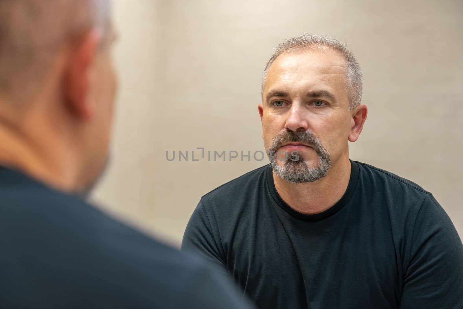 Middle-aged handsome man looking in mirror in a bathroom after shaving