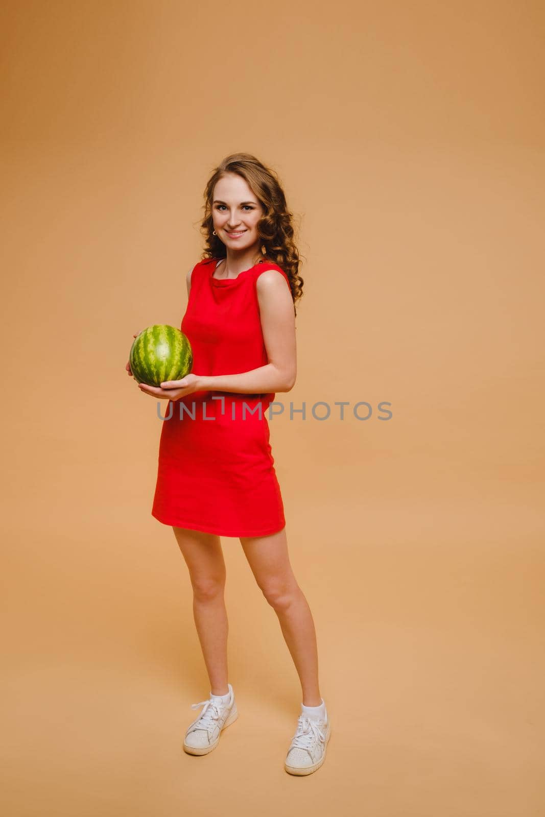 A beautiful girl in glasses and a red dress holds a watermelon in her hands by Lobachad