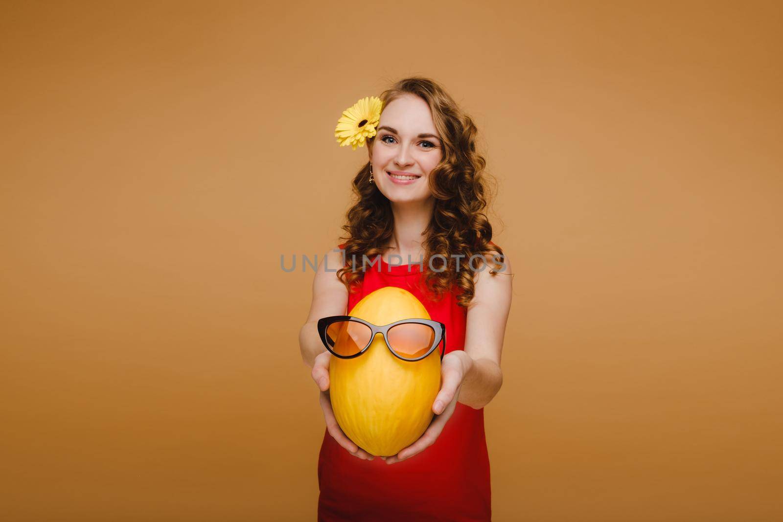 Portrait of a happy young woman holding a melon with glasses. Melon with a smile by Lobachad