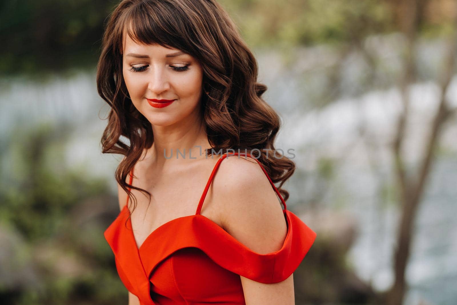 portrait of a young beautiful girl with long brown hair, in a long red dress in nature by Lobachad