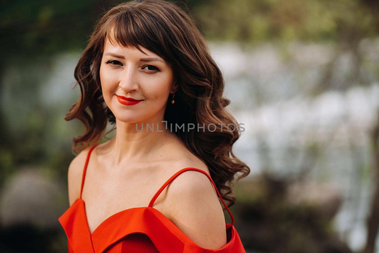 portrait of a young beautiful girl with long brown hair, in a long red dress in nature by Lobachad