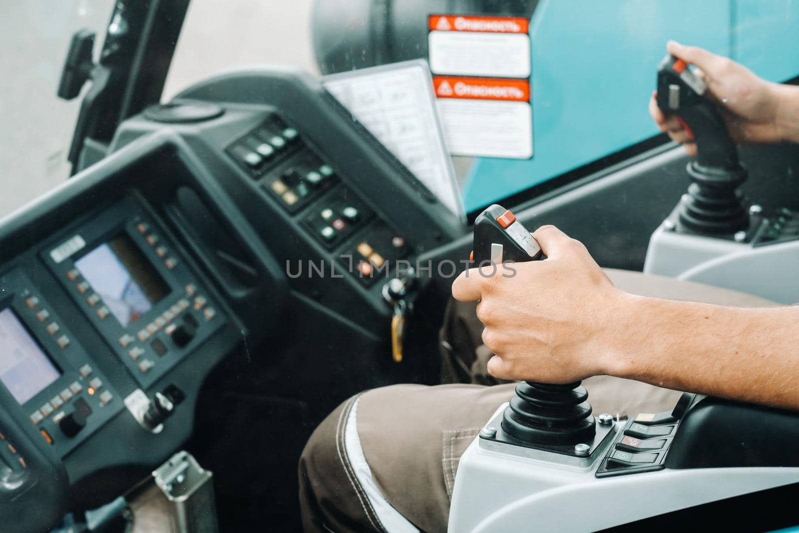 Close up of a hand holding the control stick and ready to work in the truck crane the largest truck crane for challenging tasks by Lobachad