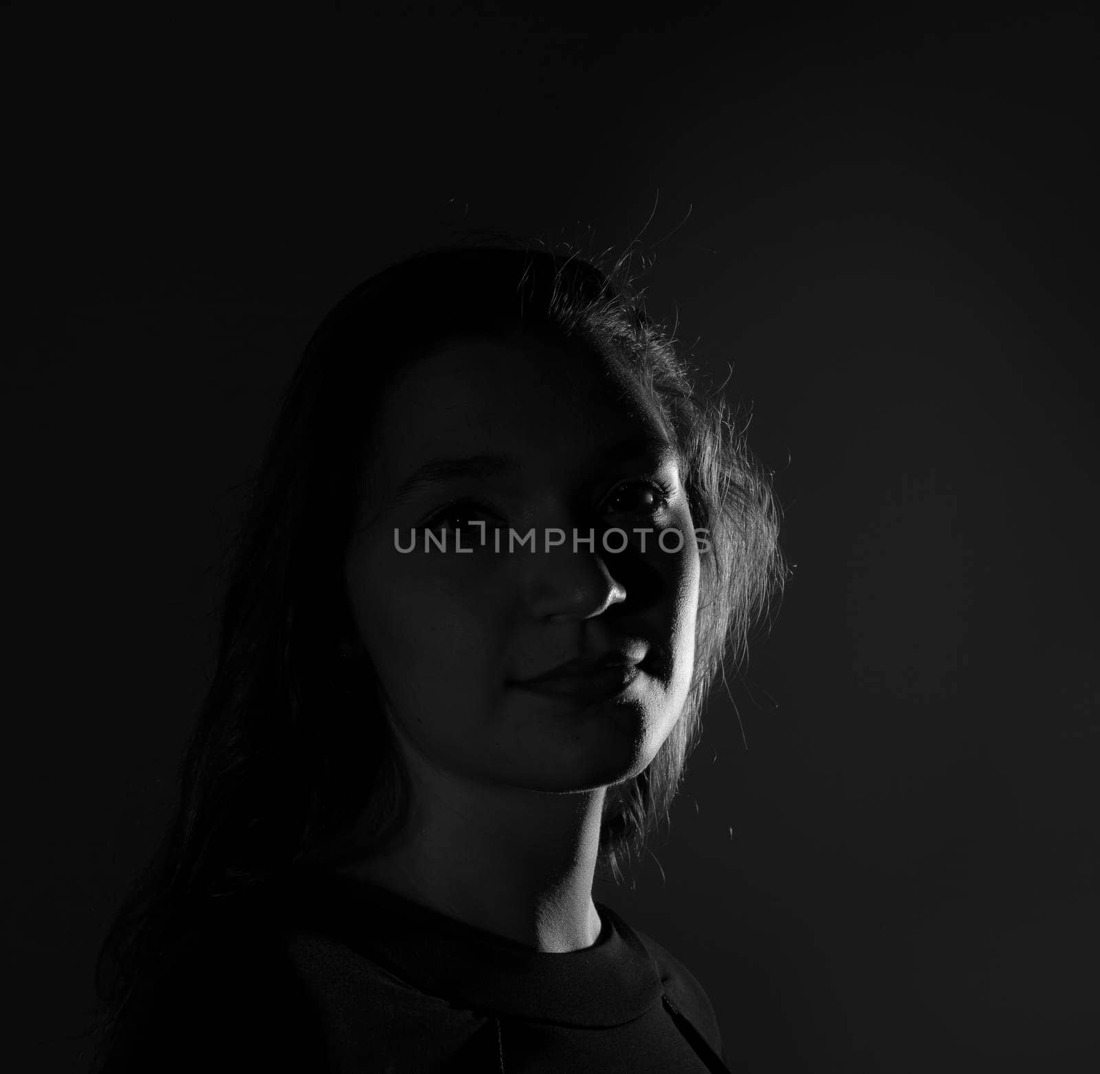 Black and white portrait of an Italian young woman on black background