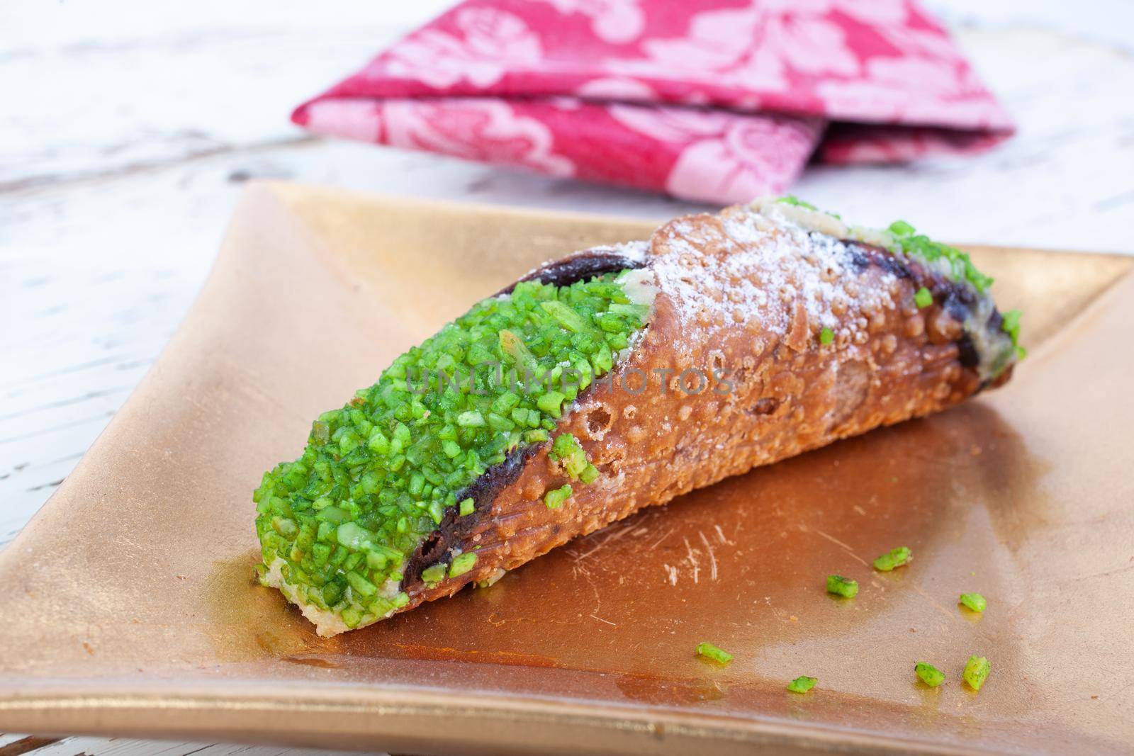Cannolo, the typical Sicilian pastry on a gold plate