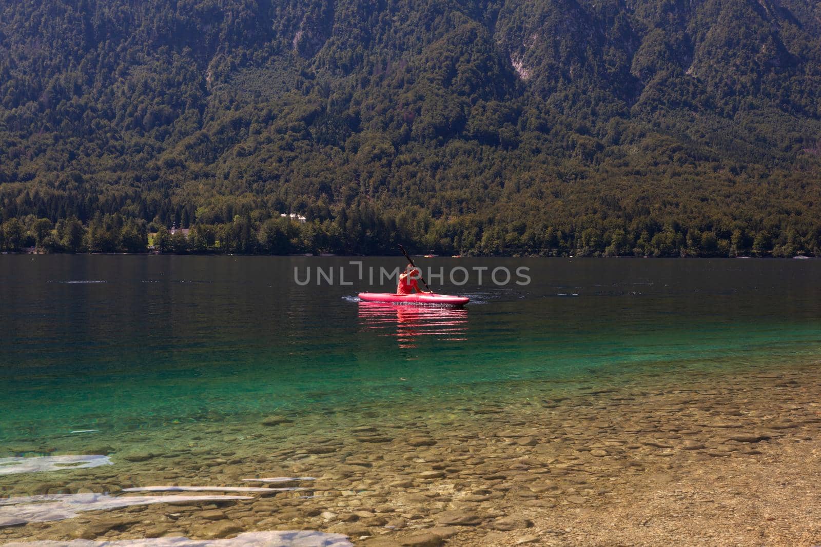 Girl kayaking in the scenic Bohinj lake, Slovenia