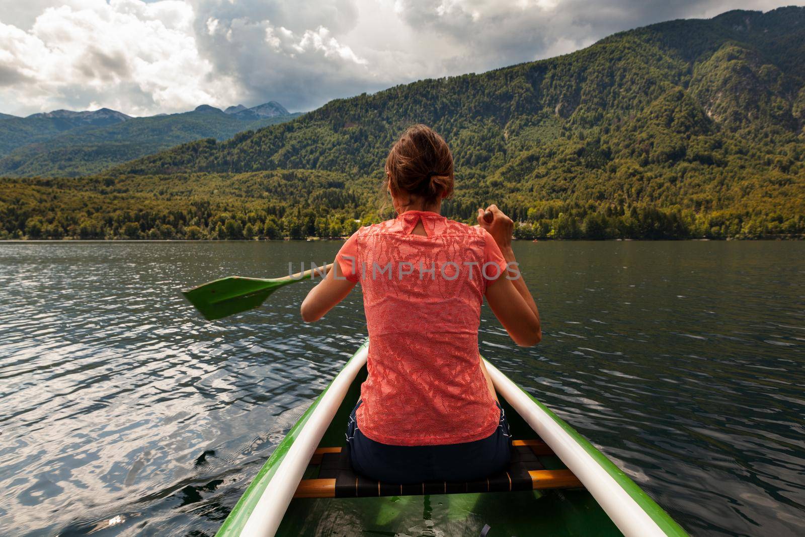 Girl kayaking in the scenic Bohinj lake, Slovenia