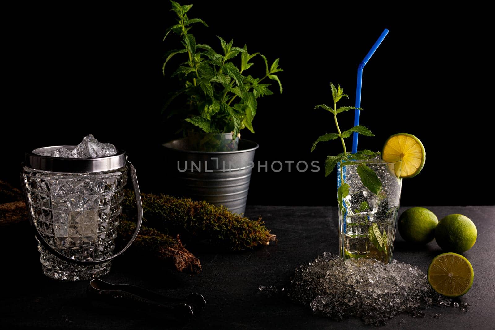 Delicious refreshing mint cocktail called mojito with rum and lime, cold drink or beverage with ice on black background