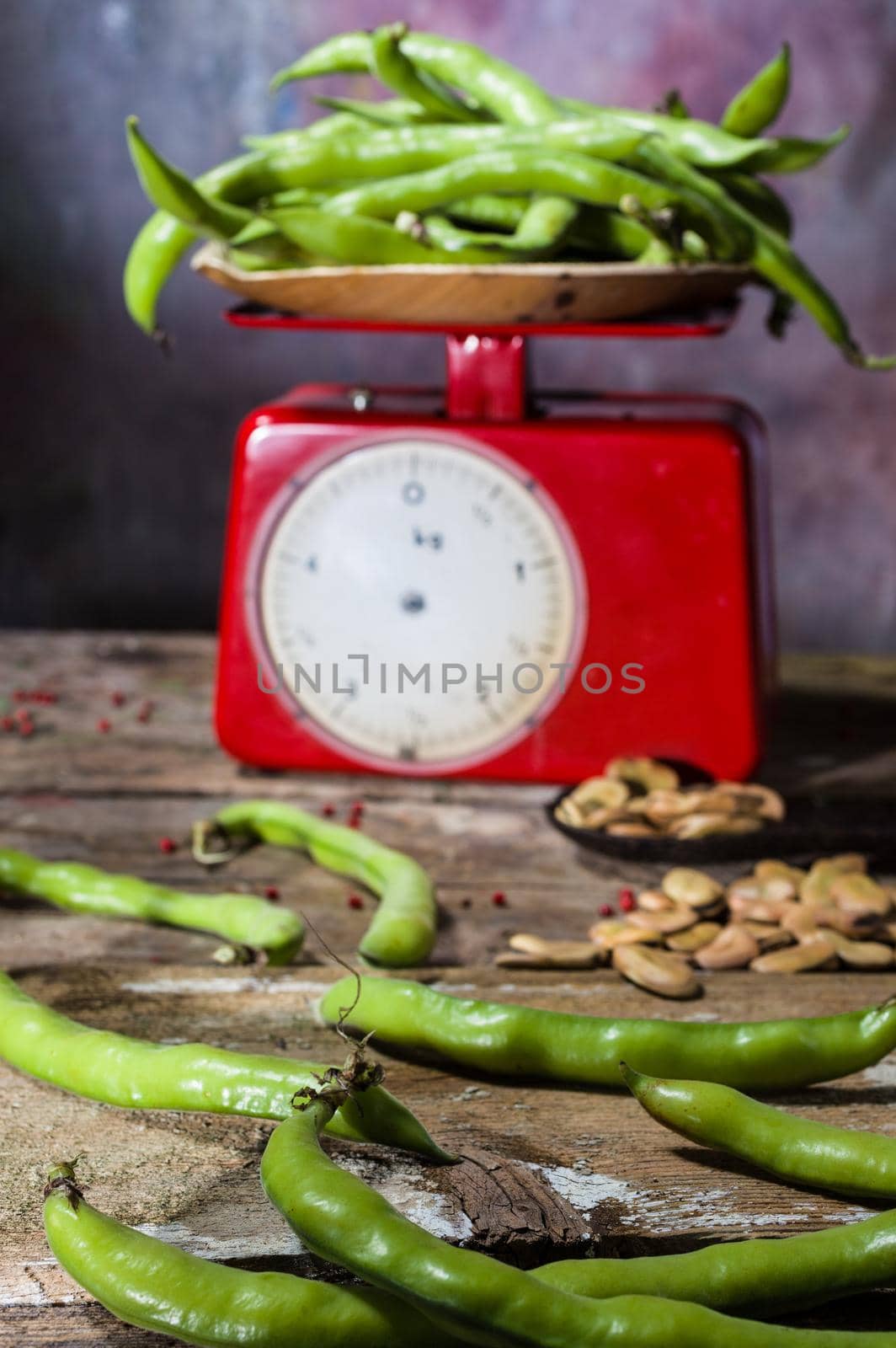 View of fresh and dried broad beans and weight scale in a wooden table