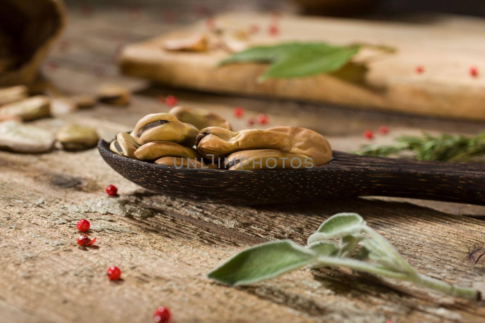 Close up of dried broad beans in the wooden ladle