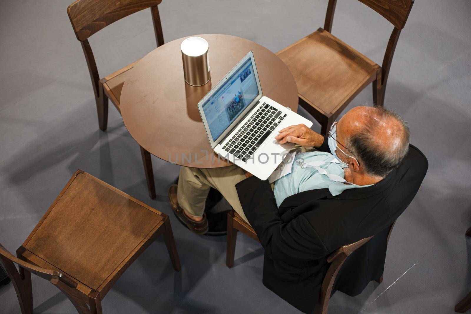 Top view of a man sitting at the table working with his notebook