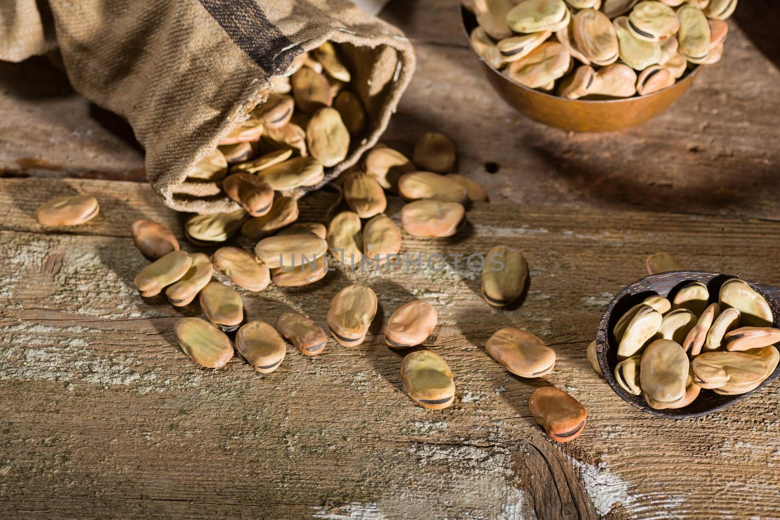Top view of dried broad beans on wooden table
