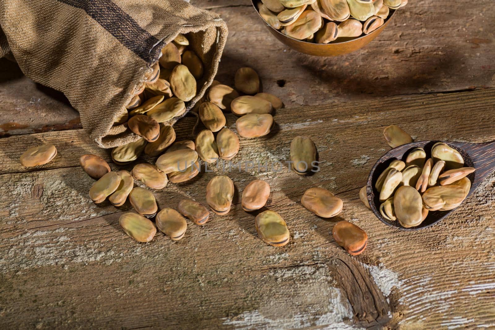 Top view of dried broad beans on wooden table