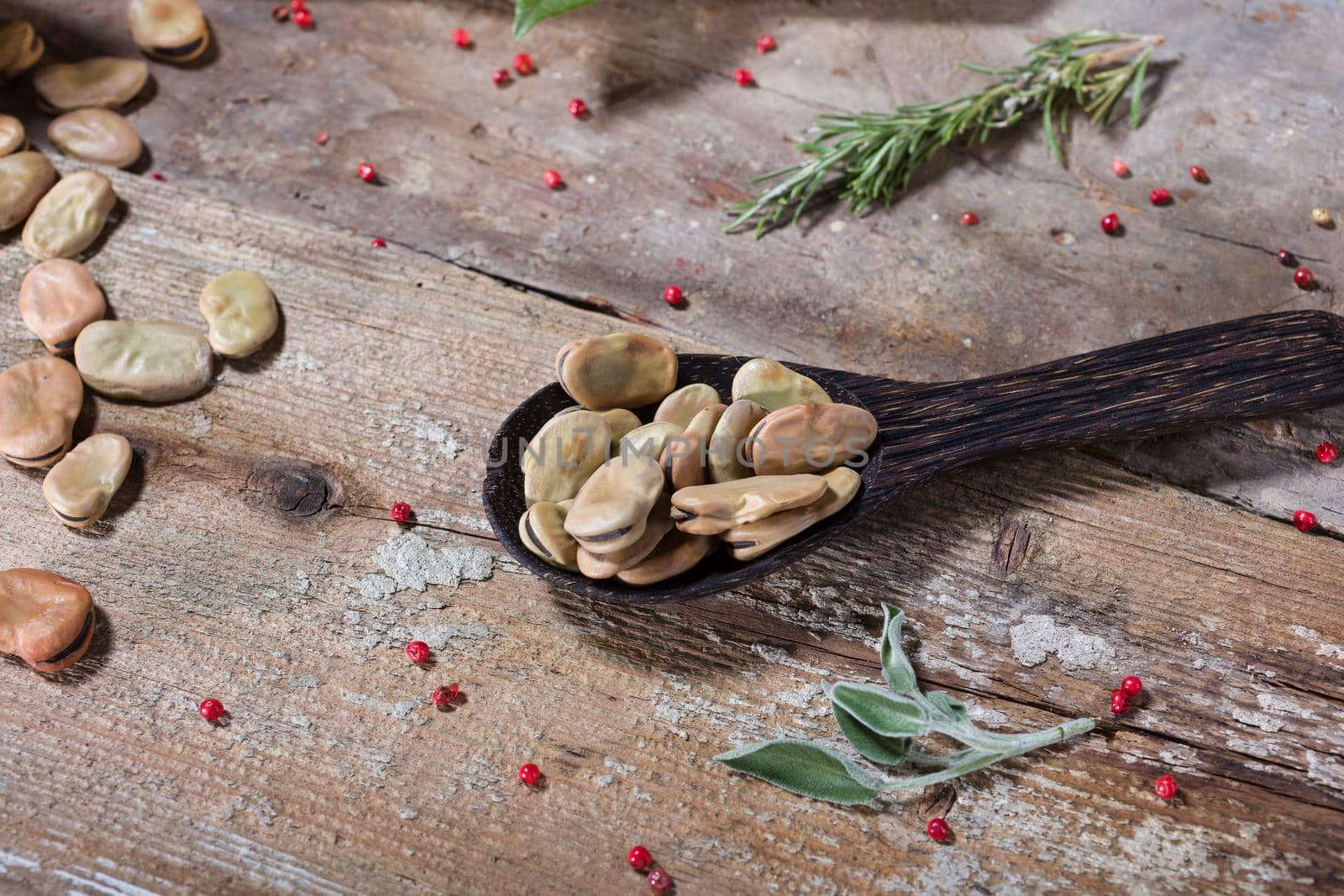 Close up of dried broad beans in the wooden ladle