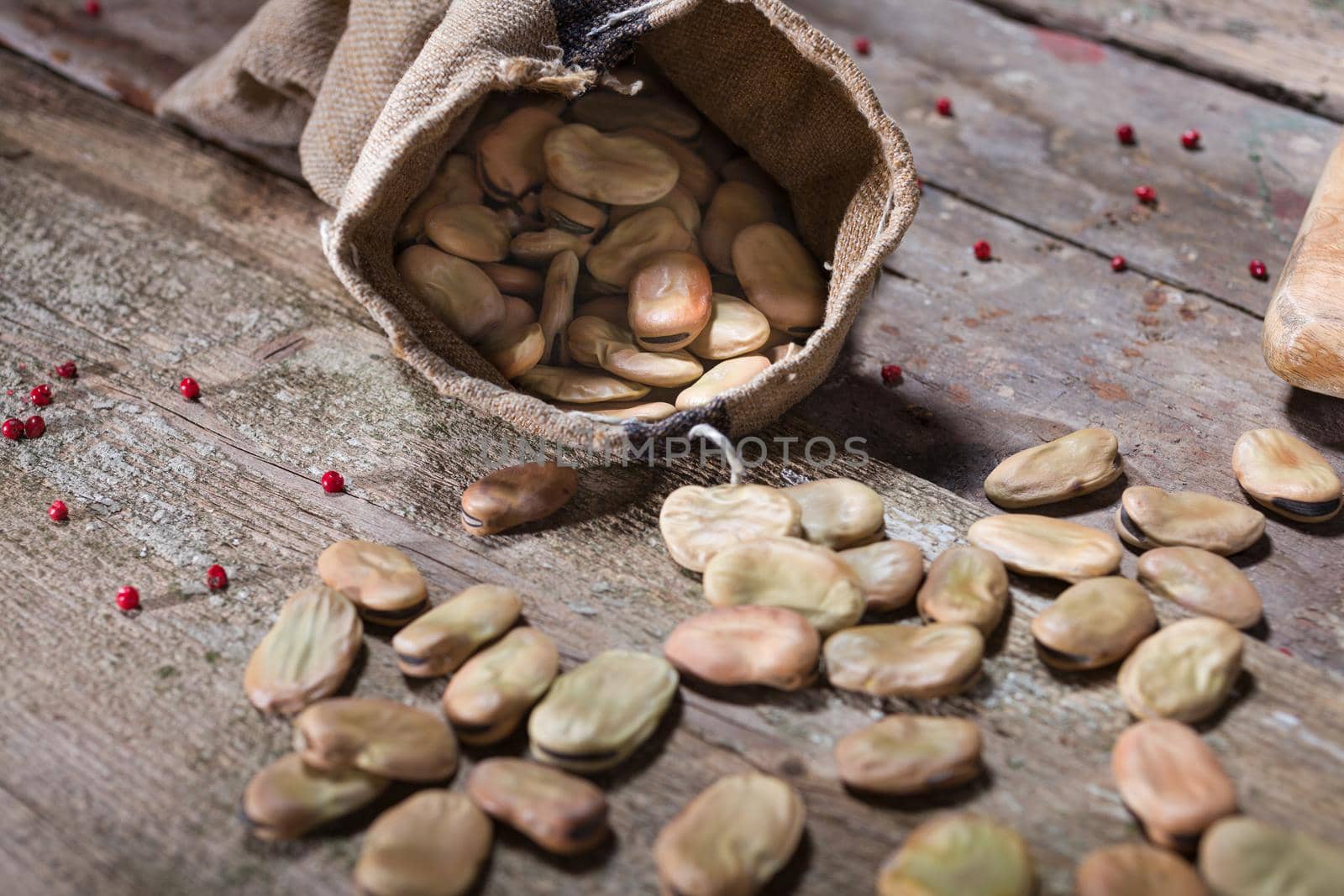 Close up of dried broad beans in a wooden table