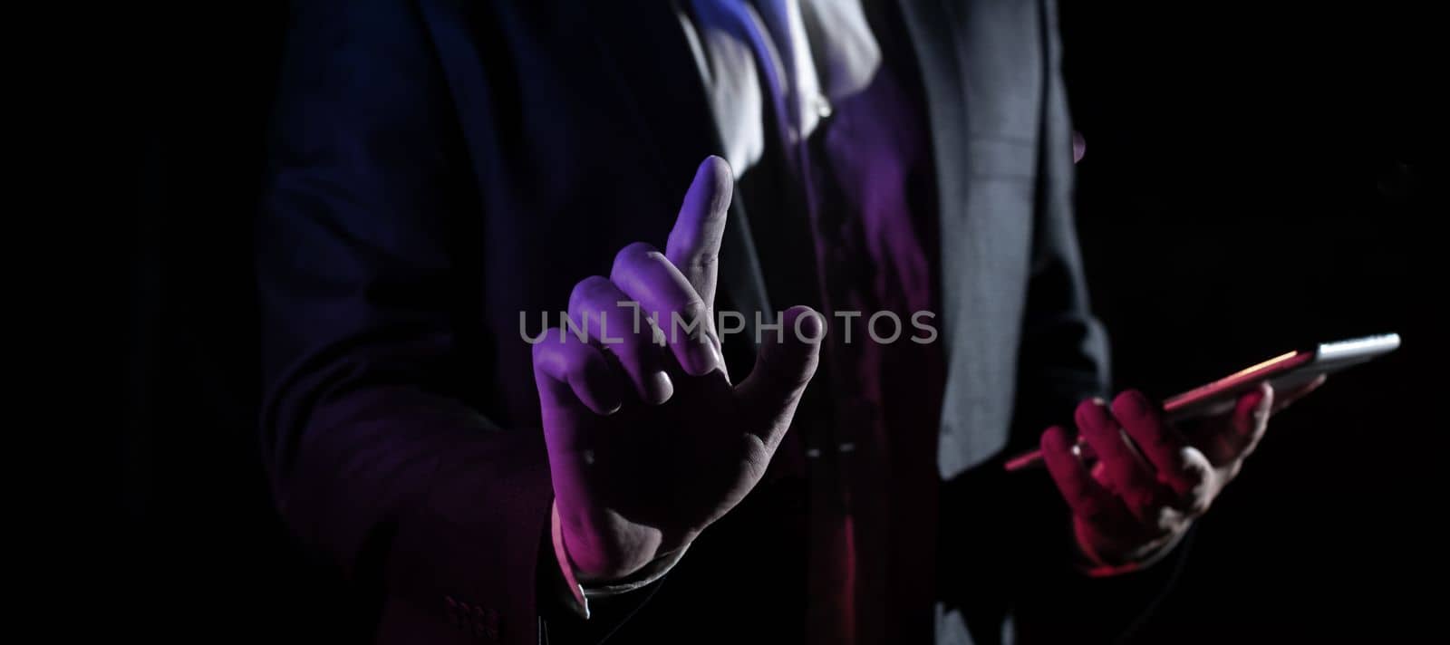 Man Holding Mobile Phone and Point On Recent Updates With One Finger. Businessman Having Virtual Reality Eyeglasses, Cellphone And Presenting New Idea. by nialowwa