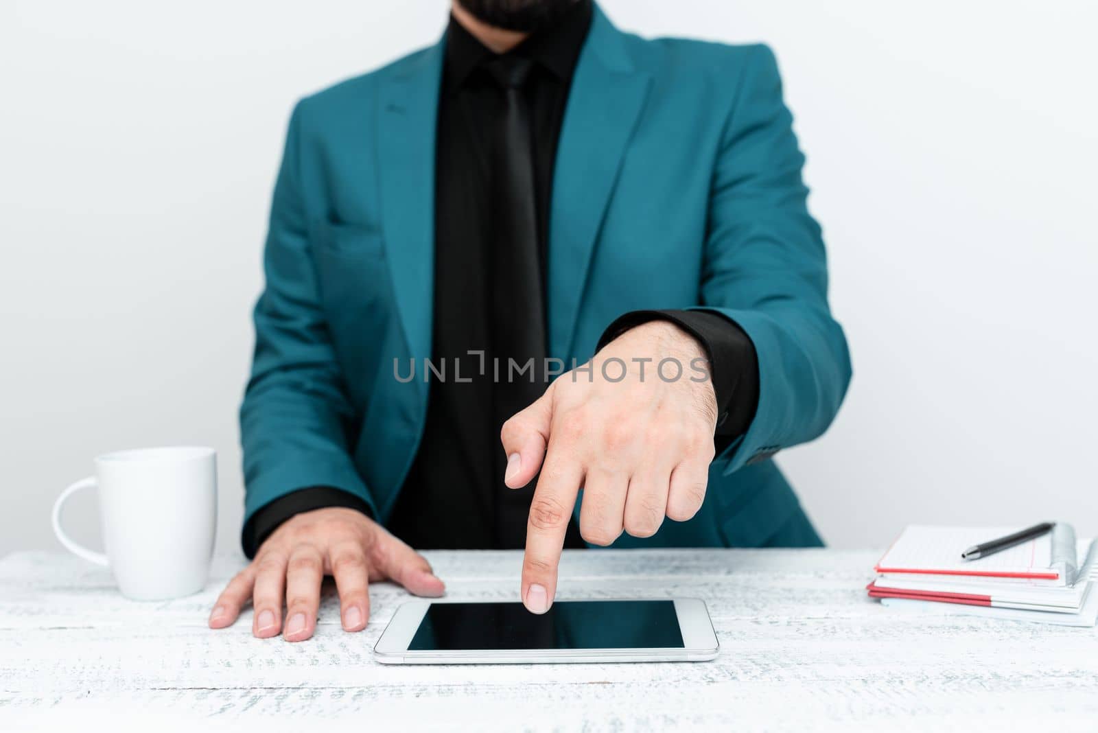Businessman in Blue jacket sitting at table And Pointing With One Finger On Important Message on the mobile phone. Gentleman Showing Critical Announcement. by nialowwa