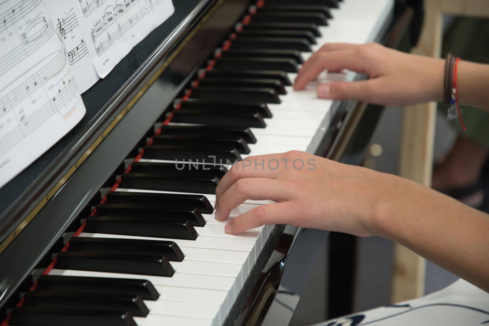 teenage girl playing the piano in the classroom, music hobby. High quality photo