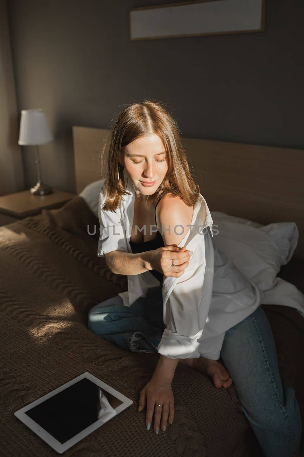 Portrait of young beautiful woman near window with shadow with digital tablet. Morning spring aesthetics and social networks digital technologies concept by Satura86