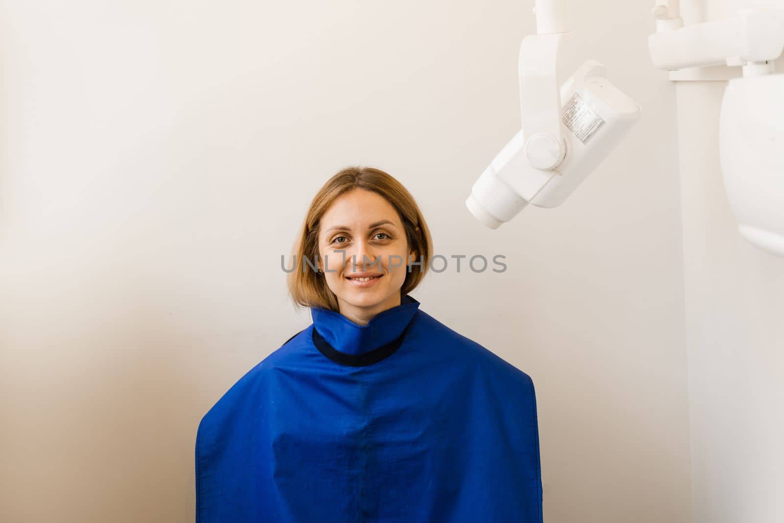 Attractive woman patient with x-ray tooth scan stomatology medical equipment in dentistry. Teeth x ray scanning for detect toothache and treat roots. by Rabizo