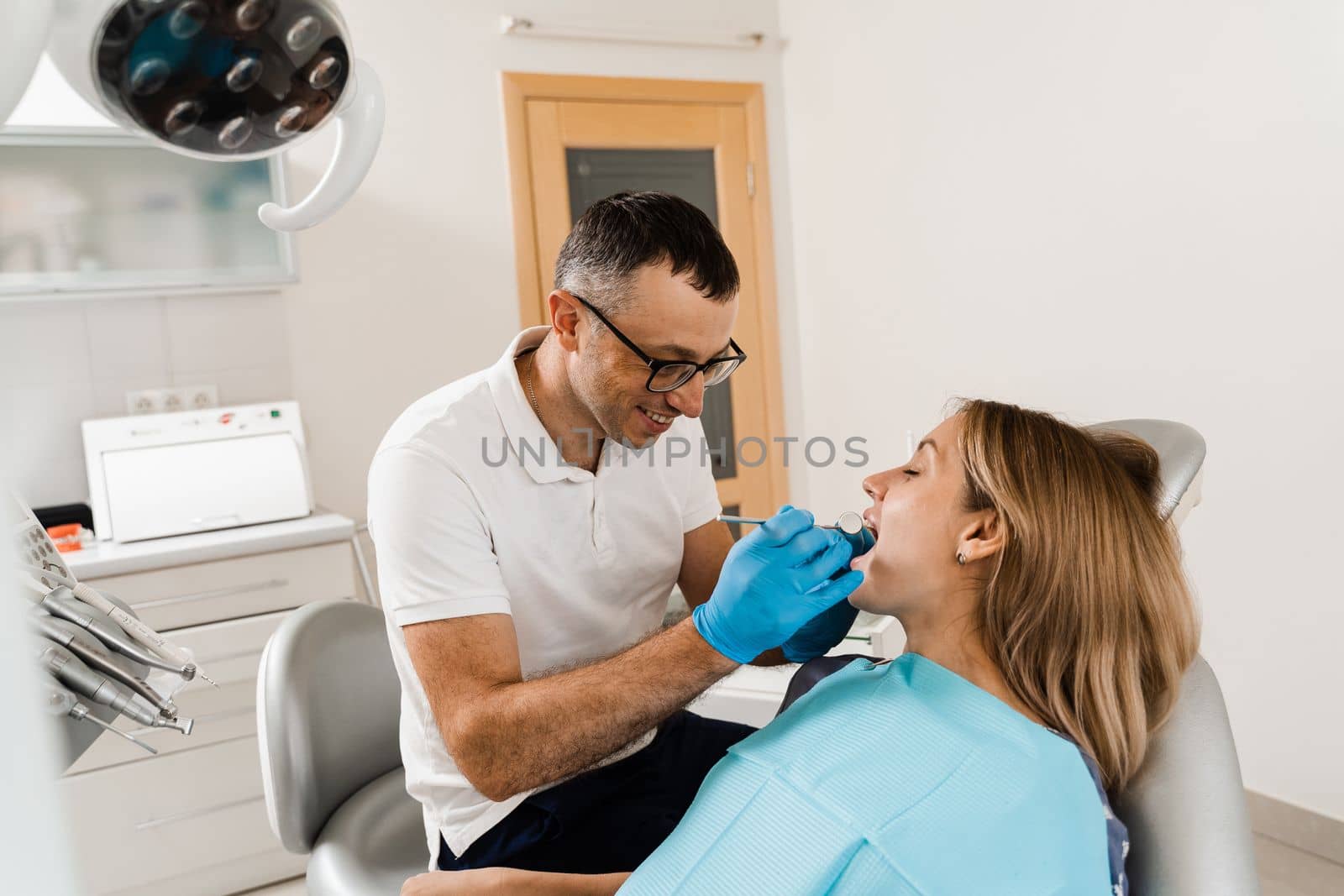 Dentist examines teeth of woman for treatment of toothache. Pain in teeth. Consultation with dentist in dentistry. by Rabizo