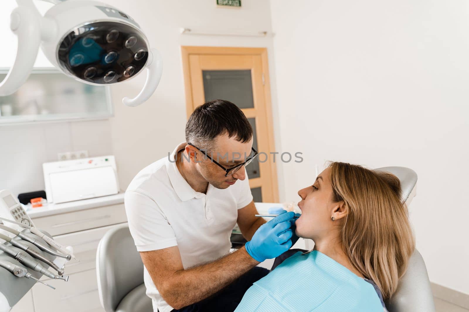 Dentist examines teeth of woman for treatment of toothache. Pain in teeth. Consultation with dentist in dentistry