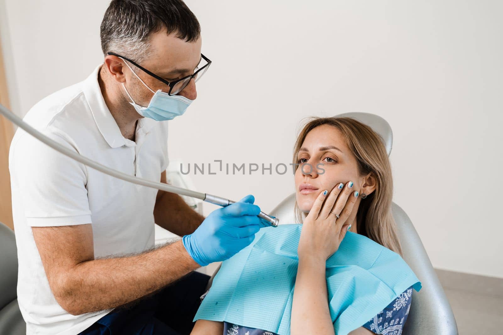 Attractive woman afraid of dentist. Dentist consults frightened girl in dentistry. Treatment of teeth and toothache in dentistry. by Rabizo