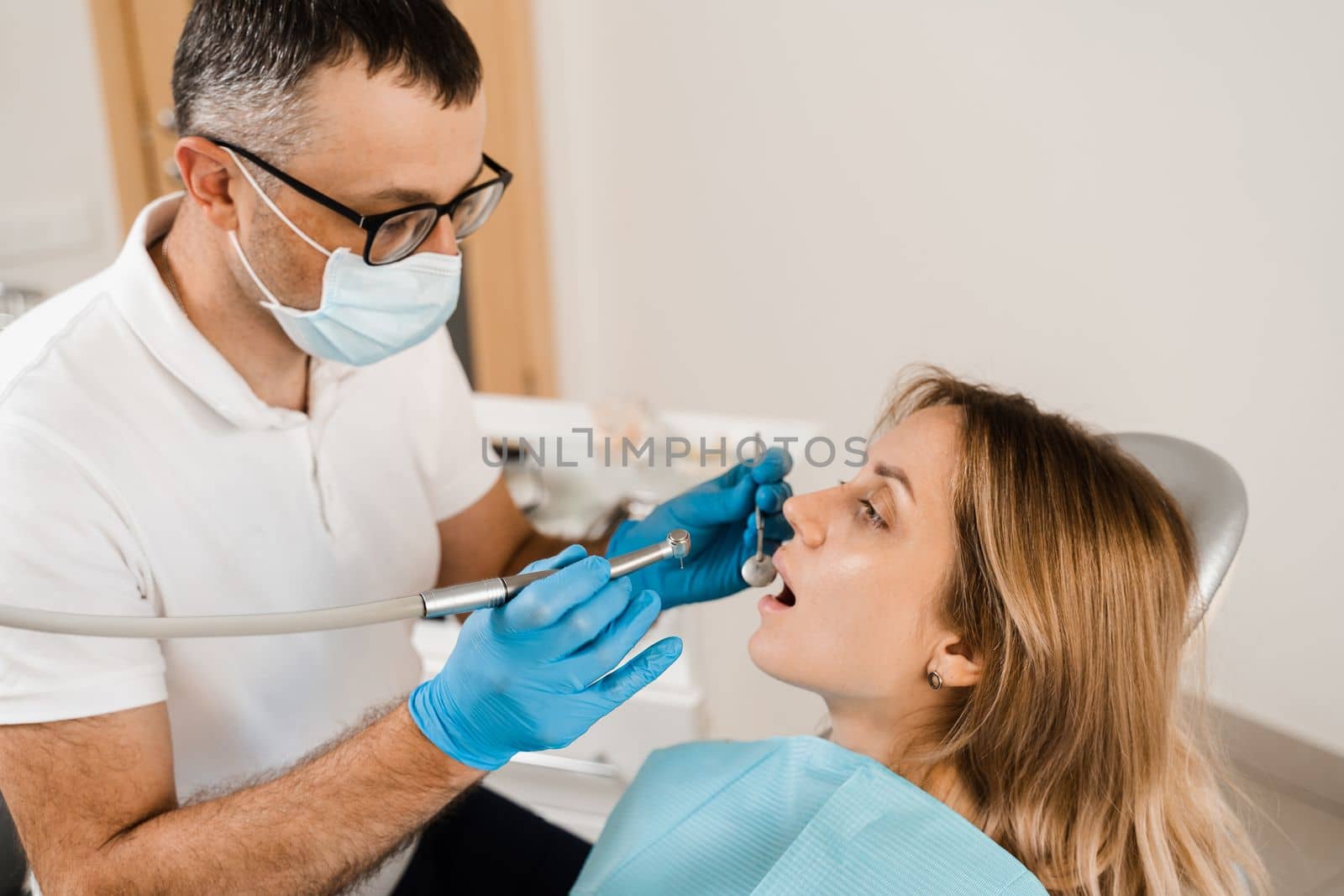 Dental drill. Dentist drilling teeth of woman in dentistry clinic. Dental filling for girl patient. by Rabizo