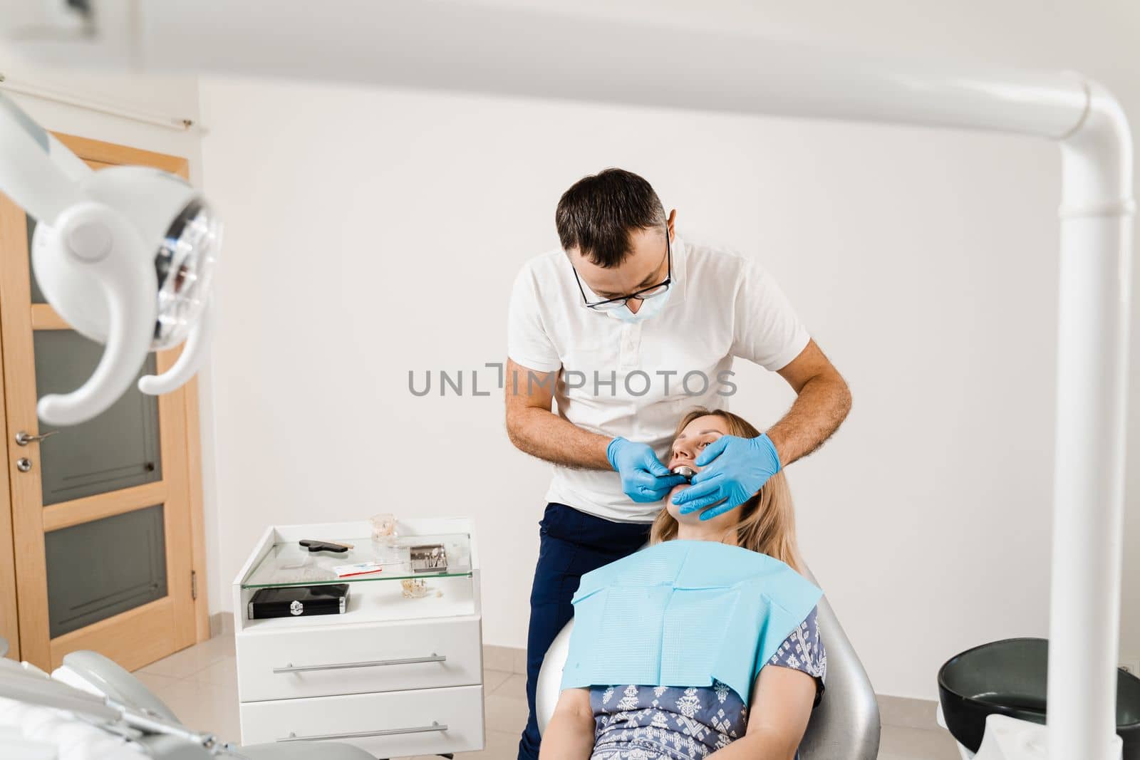 Procedure of creating dental prostheses, crowns and aligners. Doctor inserts impression tray and making cast of teeth to patient in dentistry before dental implantation.