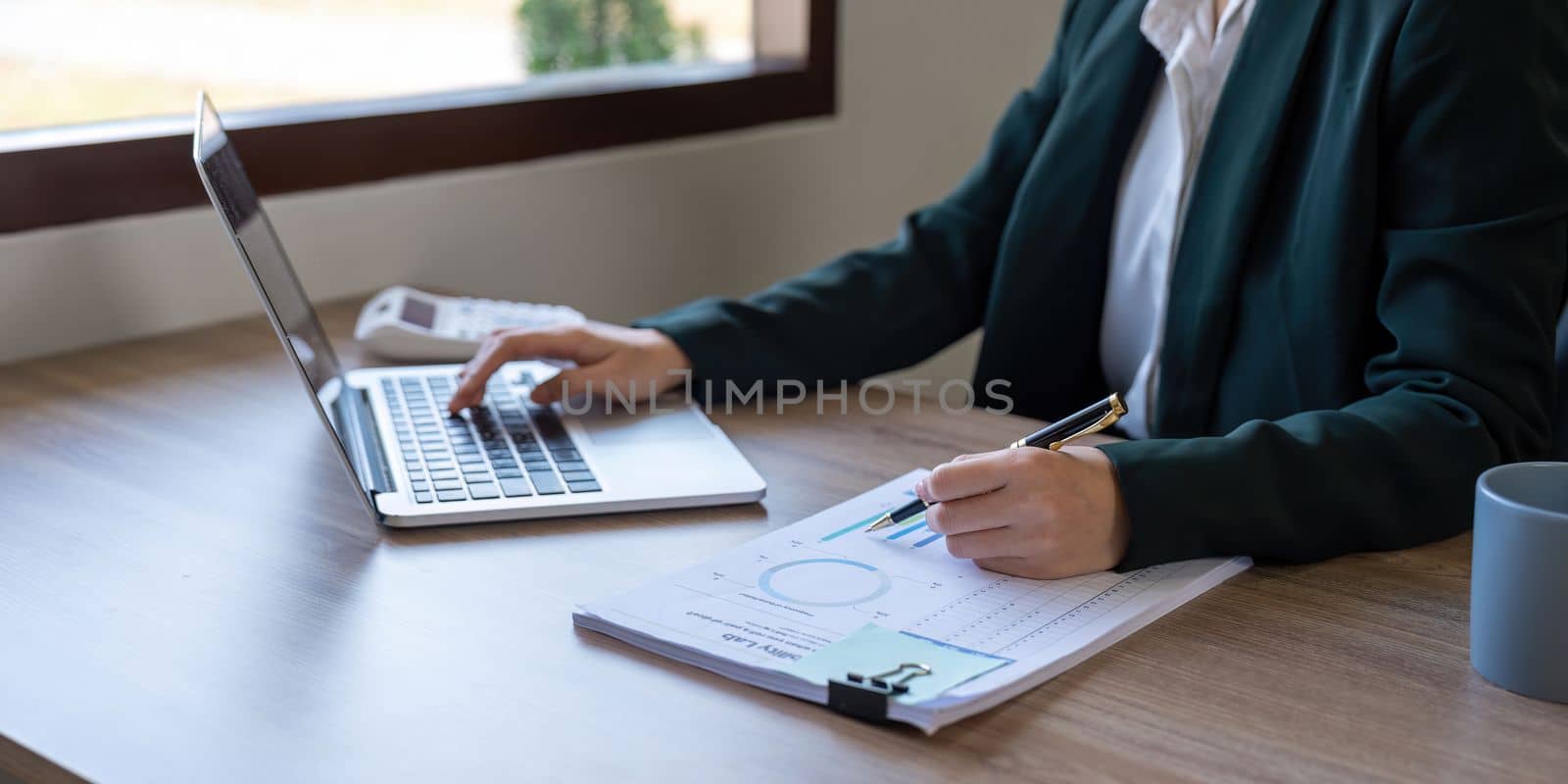 Business woman calculating figures in company financial documents with a calculator, analysis of company financial data, Planning to assess and review budgets, concept of finance and investment.