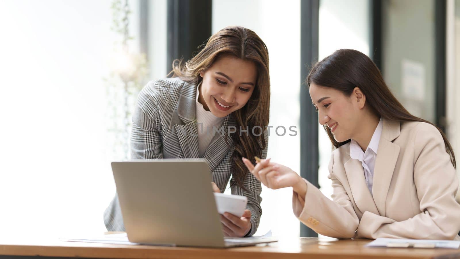 Two young Asian businesswoman discuss financial management planning. new startup project ideas analysis of financial planning and statistics and the investment market at the office..
