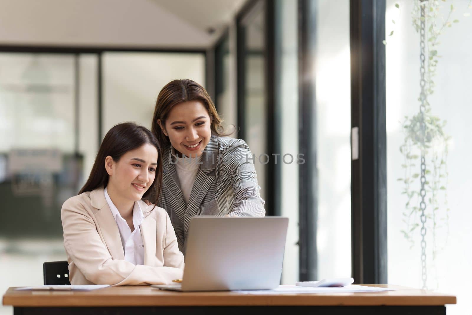 Two young Asian businesswoman discuss financial management planning. new startup project ideas analysis of financial planning and statistics and the investment market at the office..