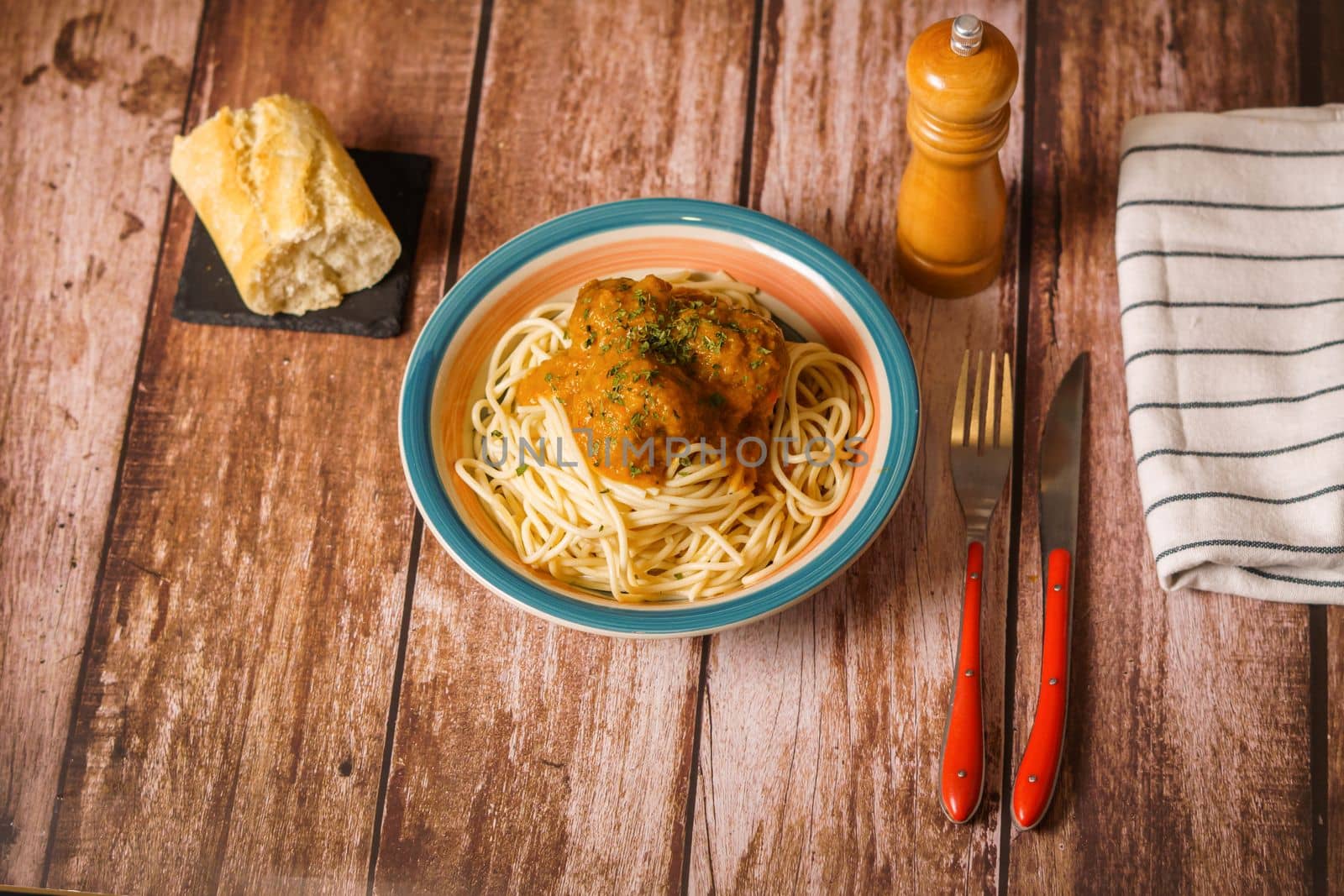 plate of meatballs with spaghetti with cutlery and bread by joseantona