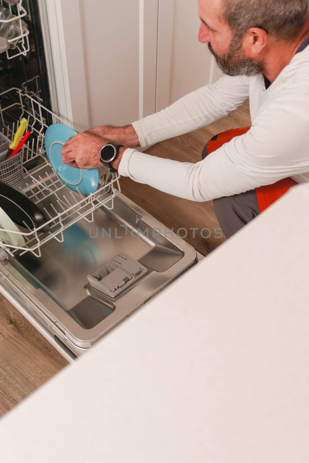 man putting dishes in the dishwasher by joseantona