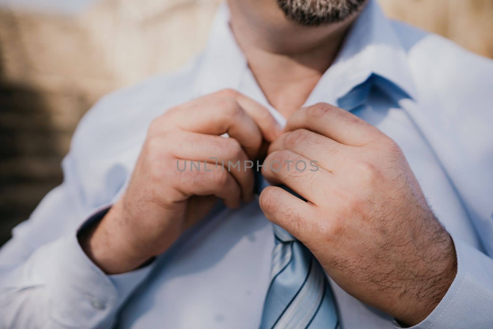 Close up of Man Adjusting Tie of Suit. Businessman in white shirt straightens his tie, close-up.