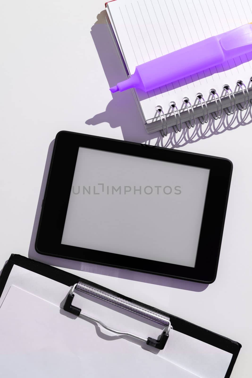 Tablet Screen With Important Ideas On It And Note Sticked On It On Desk With Notebook And Marker. Cellphone With Crutial Informations And Memo Attached To It. by nialowwa