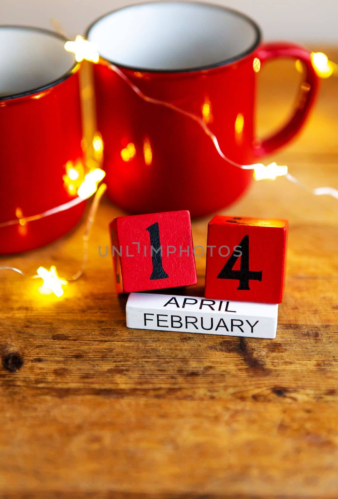 Two cups of coffee in red cups on a background of garlands. Postcard with date and month. Morning surprise for Valentine's Day. View from above. by sfinks