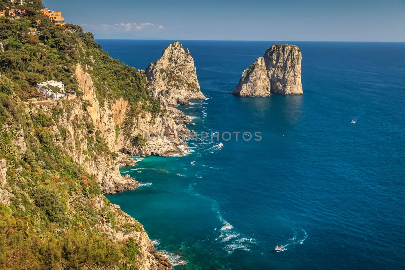 Above Capri city cliffs and Faraglioni with boats and yacht, amalfi coast, Italy by positivetravelart