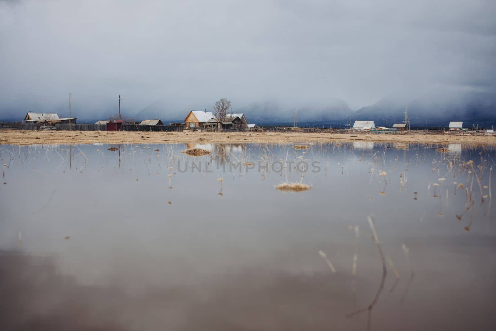 Mirror reflection of Khurai-hobok village in the dense fog against the background of the Sayan Mountains