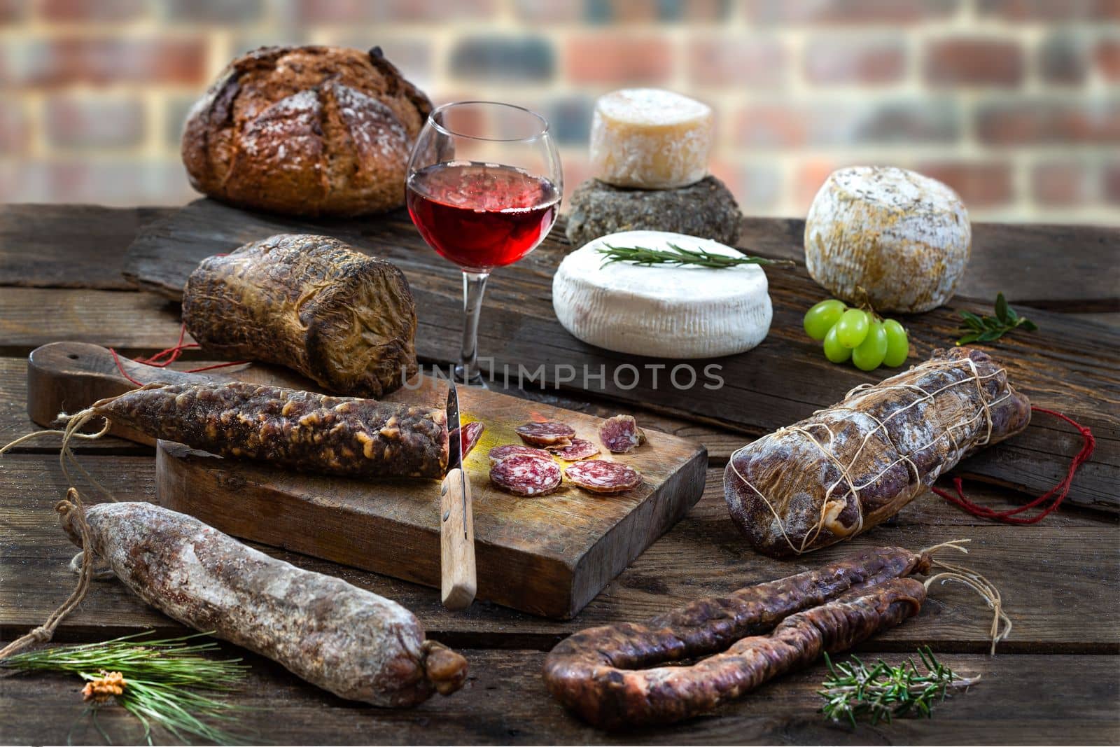 Local wild pork delicatessen, and corsican cheese, on an old brick wall background by JPC-PROD