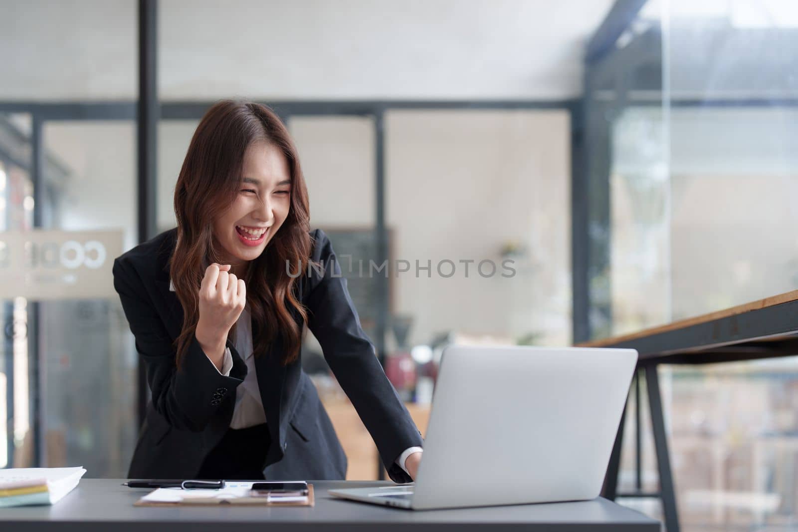 Portrait of Happy asian business woman with laptop computer in office. Woman in suit at office.