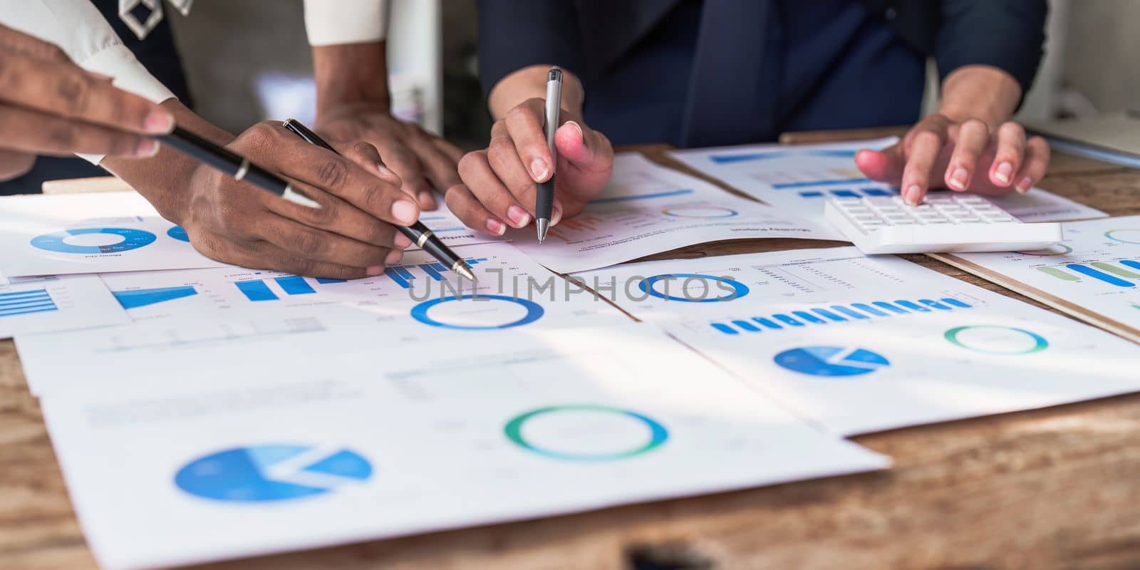 Close up of Diverse colleagues gather brainstorm discuss financial statistics at office meeting. finance, teamwork concept.