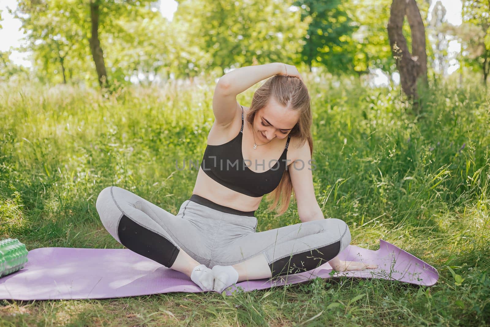 Yoga woman on green grass girl relaxes in the field. Yoga woman in green park girl doing gymnastics outdoors. Meditating woman in meditation in yoga pose practices outdoors