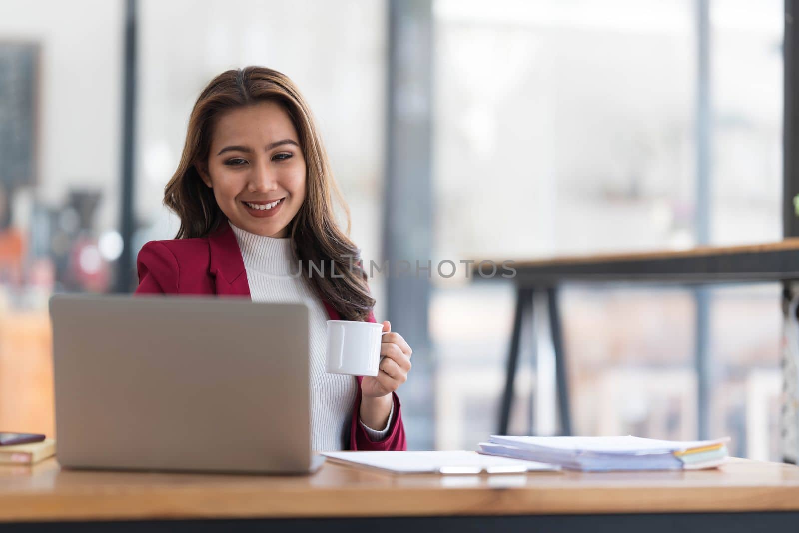 Attractive young asian woman using laptop computer while standing in a office...