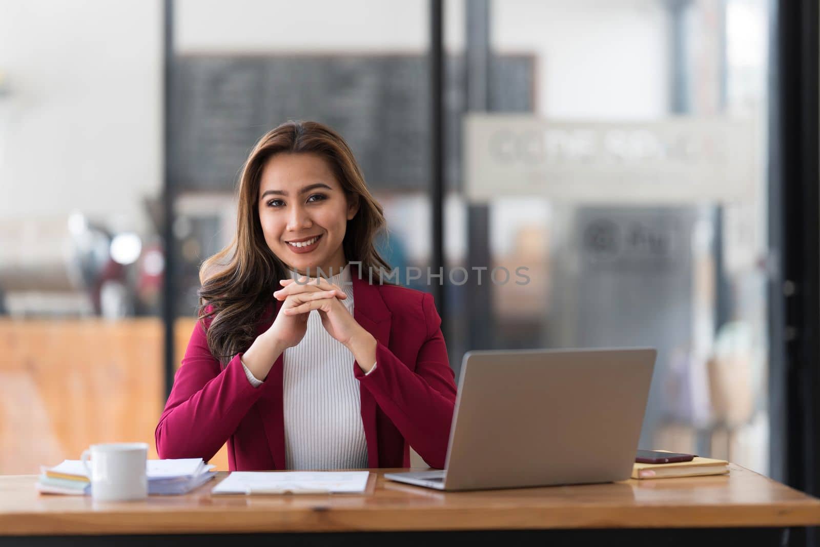 Attractive young asian woman using laptop computer while standing in a office...