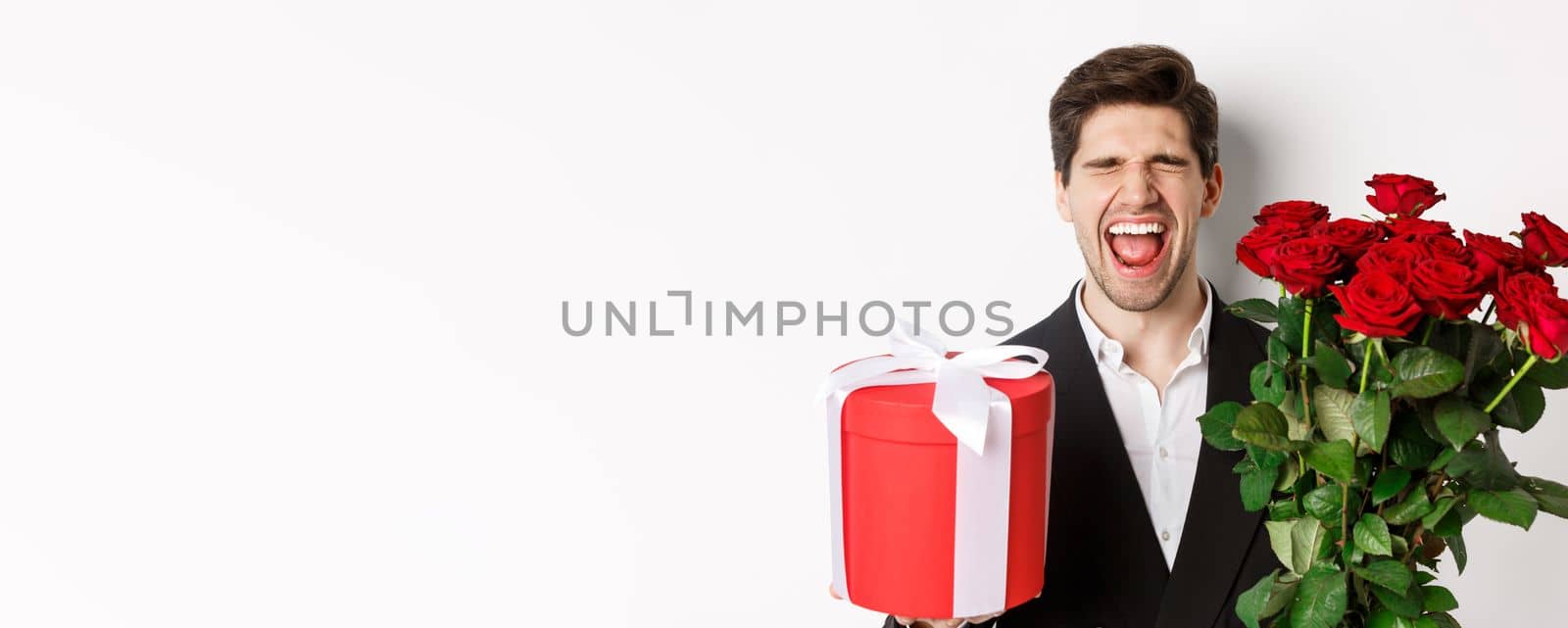 Image of sad guy in suit, got rejected and crying, holding bouquet of roses and present, standing miserable against white background by Benzoix