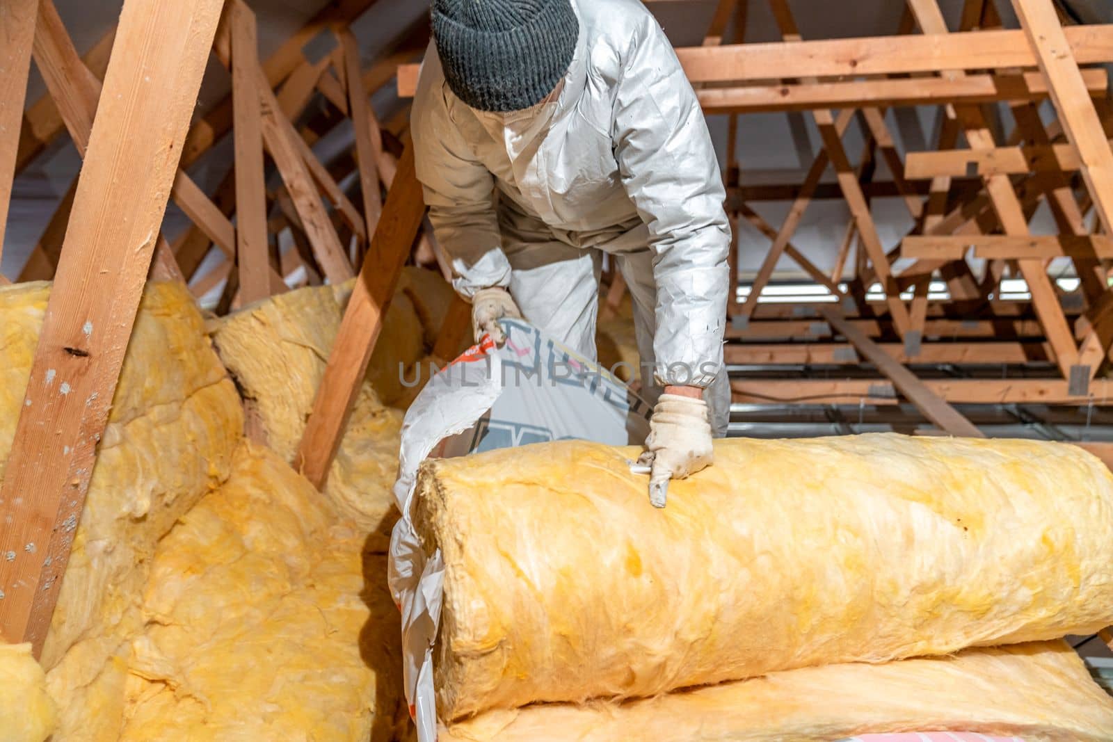 insulation of the house under the roof with the help of glass wool.