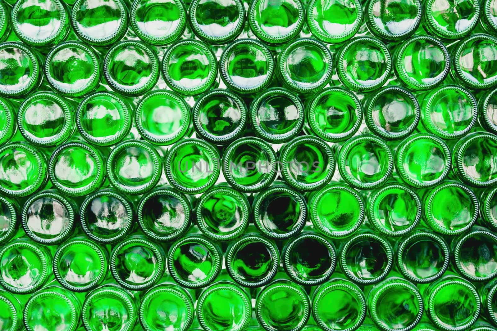 Glass bottles green. Green glass bottles of beer. Wall formed by green bottles. Green bottles background. Empty Glass Bottle with Lighting.